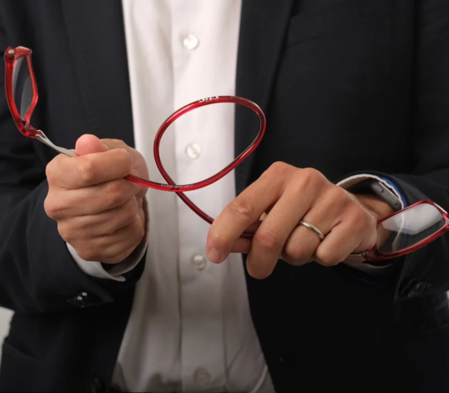 Des mains ouvrent une paire de CliC rouge par l’aimant du milieu