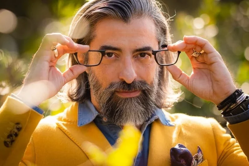 Homme en veste jaune qui met ses lunettes de lecture CliC